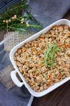 Top view of white baking dish full of stuffing sitting on a grey towel