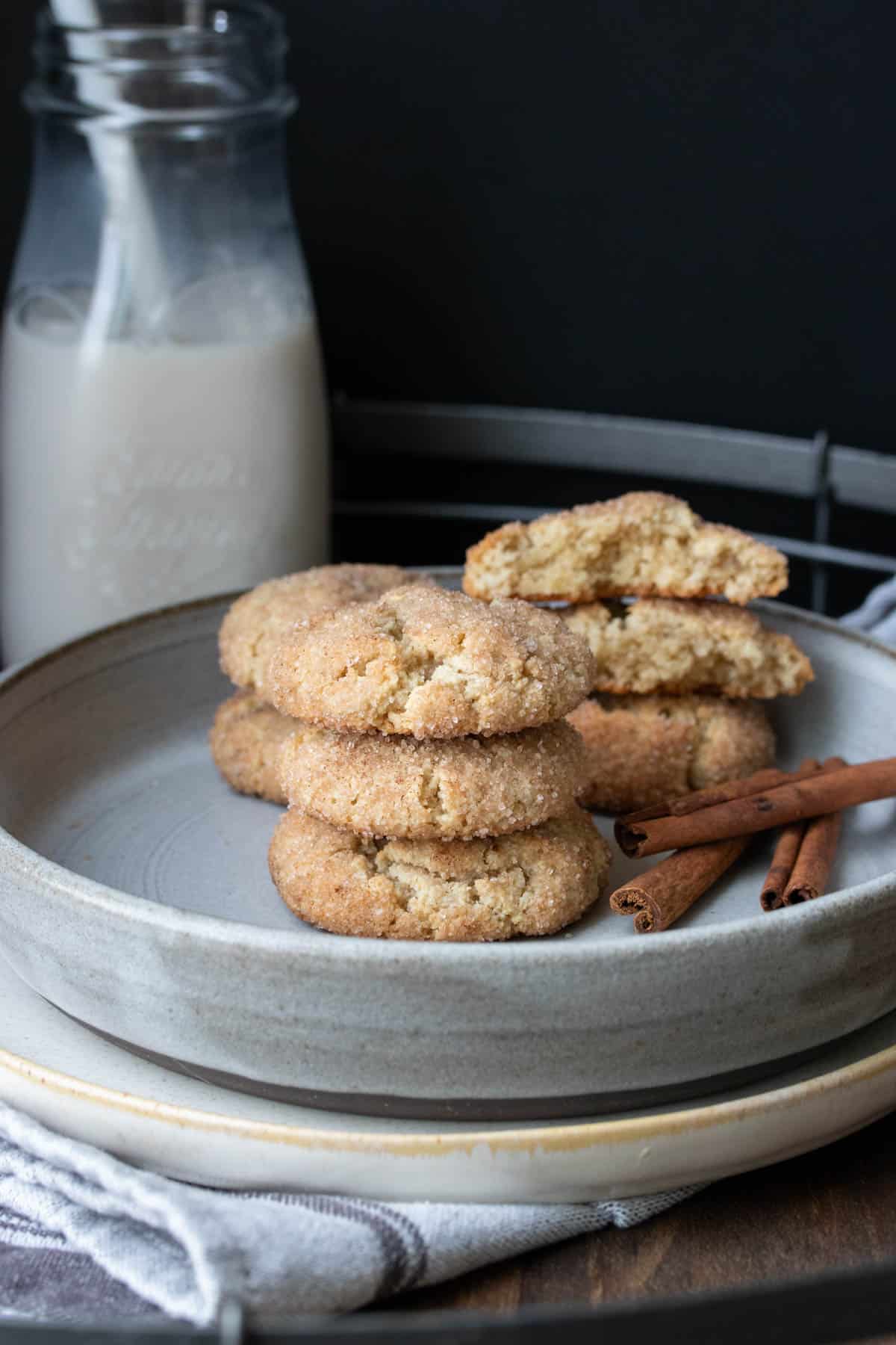 Grey plate with snickerdoodle cookies in front of a glass jar of milk