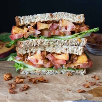 Two halves of a coconut bacon BLT with peaches, stacked on top of each other