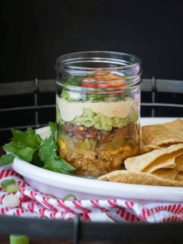 A glass jar with layers to form a 7 layer Mexican dip.